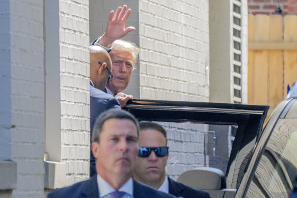 Former president Donald Trump waves as he departs the Capitol Hill Club on Thursday.