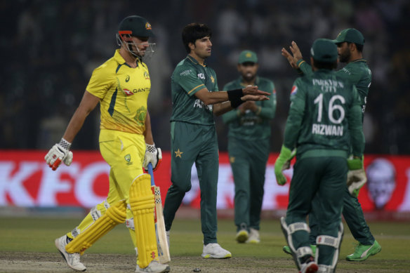 Pakistan’s Mohammad Wasim, centre, celebrates with teammates after taking the wicket of Australia’s Marcus Stoinis, left.