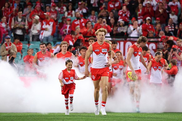 Callum Mills of the Swans leads out the Swans.
