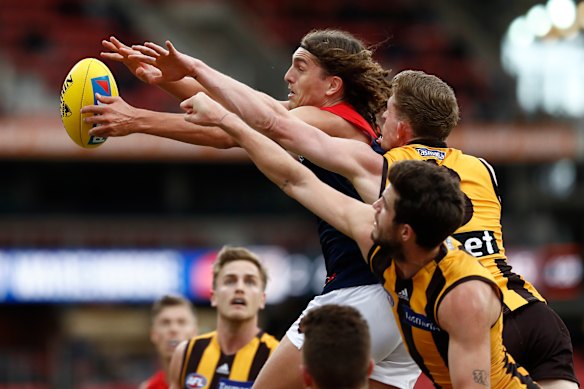Melbourne's Luke Jackson fends off a pair of Hawks.