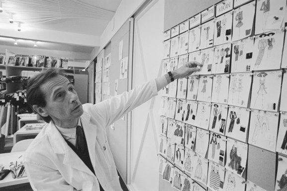Designer Marc Bohan of French fashion house Christian Dior looks at a wall of clothing sketches, 1980.
