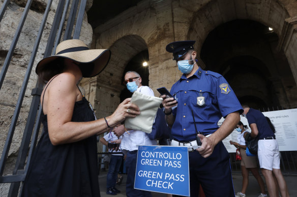 Tourists have their “green pass” checked by security staff at the entrance of the Colosseum in Rome.