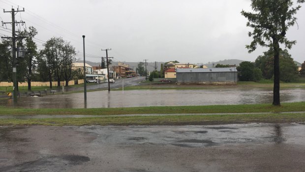 Water from the storm drain overflow laps at Hooke Street, Dungog, after heavy rainfall.
