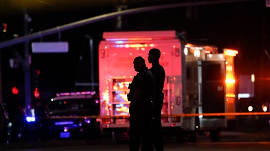 Two police officers stand outside the office building where a shooting occurred in Orange, California,