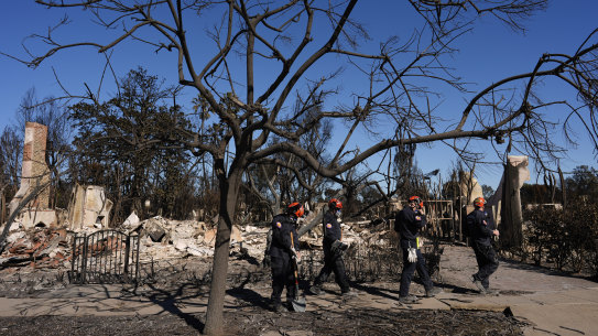 Members of a San Bernardino County Fire Department search and rescue crew work among the ruins of the Pacific Palisades neighbourhood of Los Angeles.