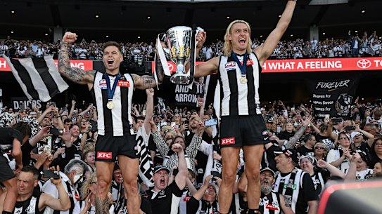 Collingwood’s Jamie Elliott and Darcy Moore celebrate their premiership victory. Fans want loyalty among their sporting stars but it’s no good as a consumer.