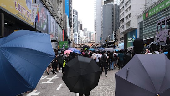 Demonstrators stand behind umbrellas during a protest against a planned national security law in the Causeway Bay district in Hong Kong.