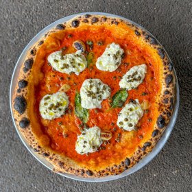 Pizza with stracciatella, vodka sauce, fried capers and confit garlic.