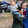 Families are escorted away from the scene of the attack at Temple Israel Synagogue in the US state of Michigan.