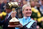 Jamie Melham poses with the 2025 Lexus Melbourne Cup after riding Half Yours to victory.