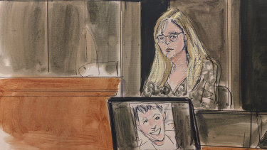 In this courtroom sketch, Annie Farmer testifies on the witness stand during the Ghislaine Maxwell sex abuse trial on Friday. A photo of Maxwell appears on a screen at foreground.