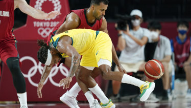 Germanyâs Johannes Thiemann, rear, fights for a loose ball with Australiaâs Patty Mills.