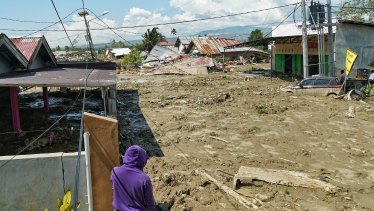 A man looks at the chaos left by the broken water embankment in Petobo, a district of Palu. A strong smell of decay is in the air, as locals says many of the victims are still trapped underneath the mud following the tsunami.