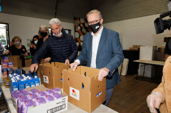 Craig Foster and Opposition Leader Anthony Albanese help pack boxes with groceries during a visit to the Addison Road Community Centre in Marrickville.