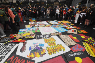 Protesters lay out signs in front of Parliament House.