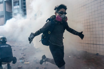 A protester flees through a cloud of tear gas in an attempt to leave Hong Kong's Polytechnic University this week.
