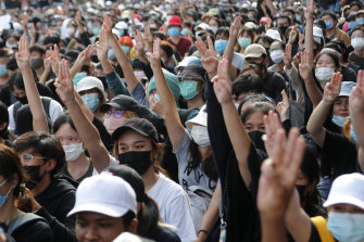 Pro-democracy students raise three-fingers, symbol of resistance salute, during a rally in Bangkok on August 16.