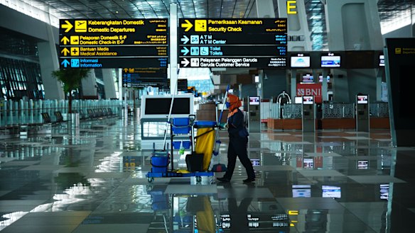 A cleaner walks through the nearly empty Soekarno-Hatta International Airport in Jakarta, Indonesia.