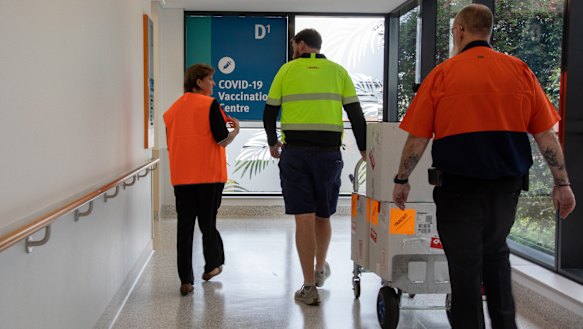 Gold Coast University Hospital Pharmacy director Liz Coombes chaperones the Pfizer vaccine into the hospital on Sunday.
