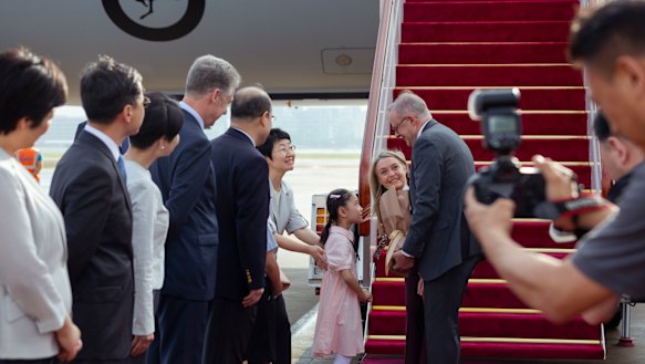 Albanese and fiancee Jodie Haydon are  met by a welcoming party in Shanghai including a local girl and dignitaries.