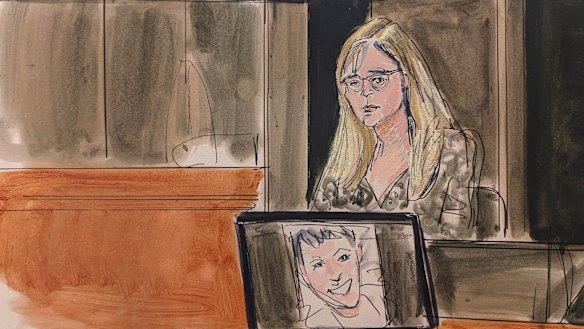 In this courtroom sketch, Annie Farmer testifies on the witness stand during the Ghislaine Maxwell sex abuse trial on Friday. A photo of Maxwell appears on a screen at foreground.