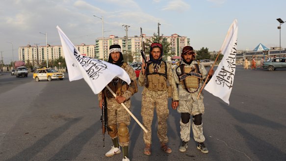 Taliban fighters hold flags in Kabul, Afghanistan.