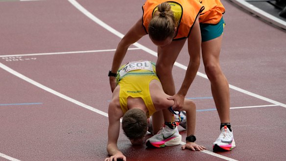 Jaryd Clifford collapses after his marathon and is assisted by his guide Tim Logan. 