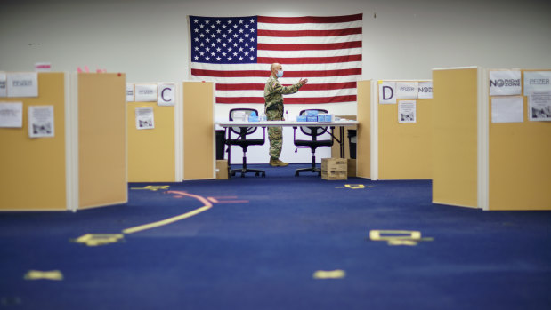 Sergeant 1st Class Joseph Griego works in a coronavirus mass-vaccination site at the former Citizens Bank headquarters in Cranston, Rhode Island. The US has an ever-growing surplus of COVID-19 vaccines, looming expiration dates while demand drops while the developing world is clamouring for doses.