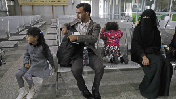 A Yemeni family waits in the departure hall at Sanaa International airport for a UN flight on Monday.