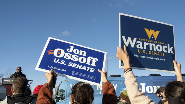 Joe Biden is travelling to Georgia to support Democratic Georgia Senate challenger the Reverend Raphael Warnock, seen here at a rally with Jon Ossoff in Atlanta.