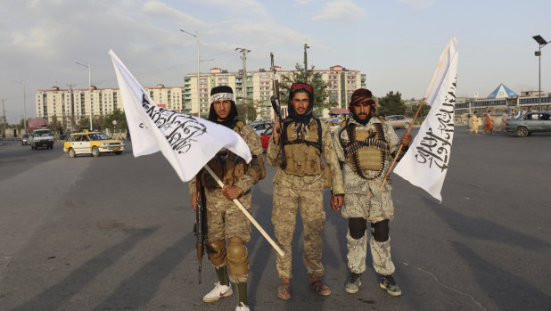 Taliban fighters hold flags in Kabul, Afghanistan.