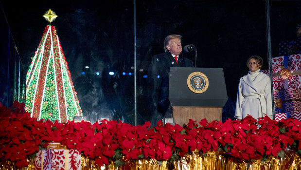 US President Donald Trump, accompanied by first lady Melania Trump, speaks during the National Christmas Tree lighting ceremony at the Ellipse near the White House in Washington last month.