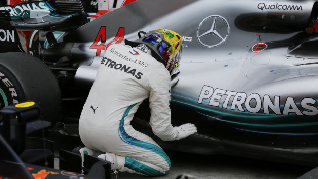 Higher power: Mercedes driver Lewis Hamilton kneels next to his car after winning the Brazilian GP.