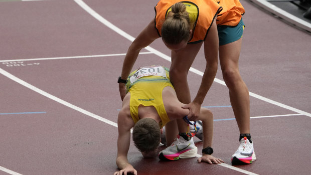 Jaryd Clifford collapses after his marathon and is assisted by his guide Tim Logan. 