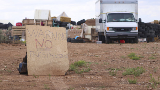 A sign stands outside the remote desert location where a family were allegedly teaching their children to be mass shooters. 