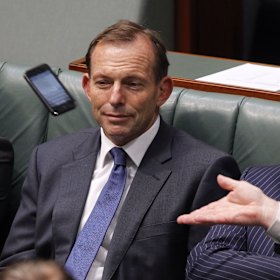 A phone flies past Tony Abbott’s head in parliament.
