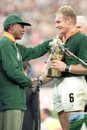 Nelson Mandela hands South African captain Francois Pienaar the Webb Ellis Trophy.