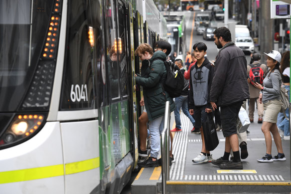 People board a tram in the city earlier this month. Fewer commuters are wearing masks on public transport, which is still mandatory. 