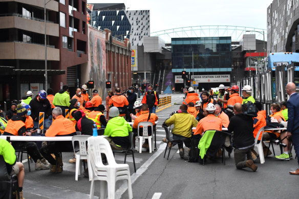 Construction workers protest the ban on tearoom gatherings, blocking Lonsdale Street during their lunch break.