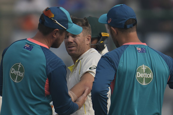 David Warner is examined after suffering a hairline fracture of the elbow during the second Test in Delhi.