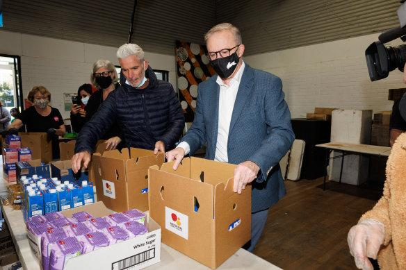 Craig Foster and Opposition Leader Anthony Albanese help pack boxes with groceries during a visit to the Addison Road Community Centre in Marrickville.