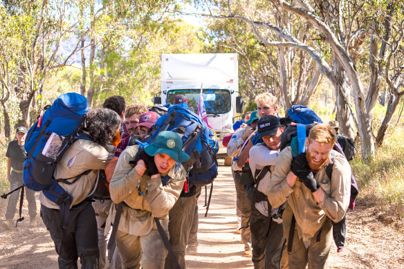 Manly players drag a five-tonne truck, loaded with another two tonnes of equipment, through the bush near Mudgee.