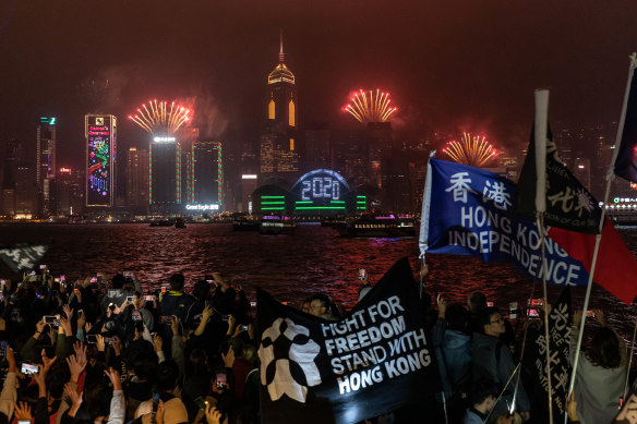 Pro-democracy supporters wave flags and shout slogans during a countdown party in Hong Kong.