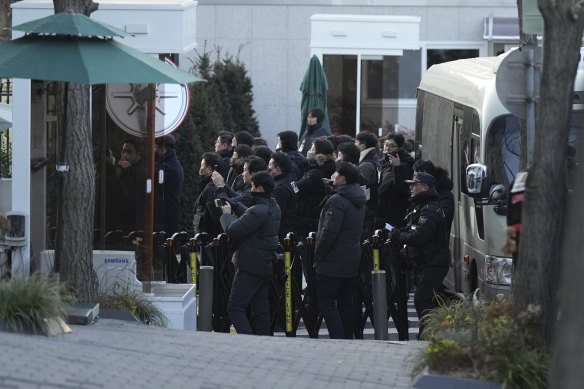 Police at the gate of the presidential residence in Seoul as Yoon Suk Yeol’s supporters stage a rally to oppose the issue of a warrant to detain him.