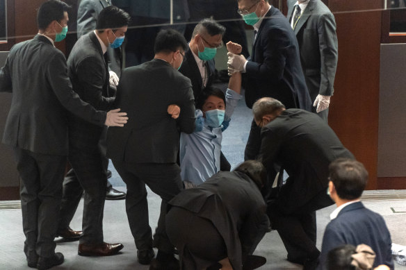 Pro-democracy member of the Hong Kong Legislative Council Ted Hui Chi-fung being removed by security during a scuffle with pro-Beijing legislators.