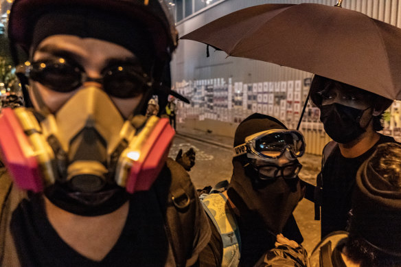 Protesters wearing tear gas masks hold umbrellas during a stand-off outside the Central Government Complex in Hong Kong.