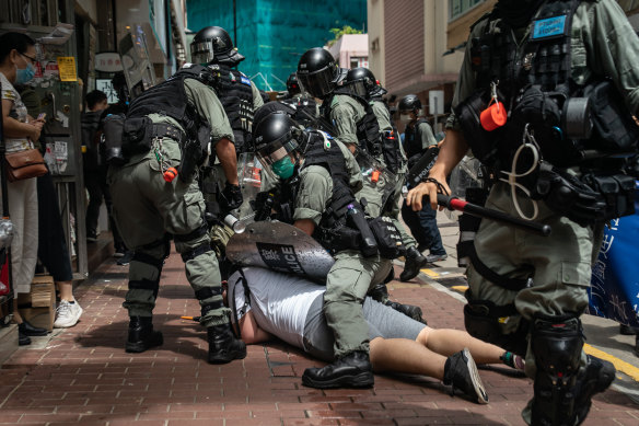  A man is detained by riot police during a demonstration on July 1.