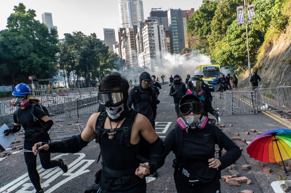 Protesters run on a street during an attempt to leave the campus.