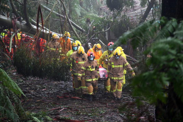 Emergency crews rescue a woman in Olinda on Thursday.