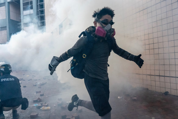 A protester flees through a cloud of tear gas in an attempt to leave Hong Kong's Polytechnic University this week.